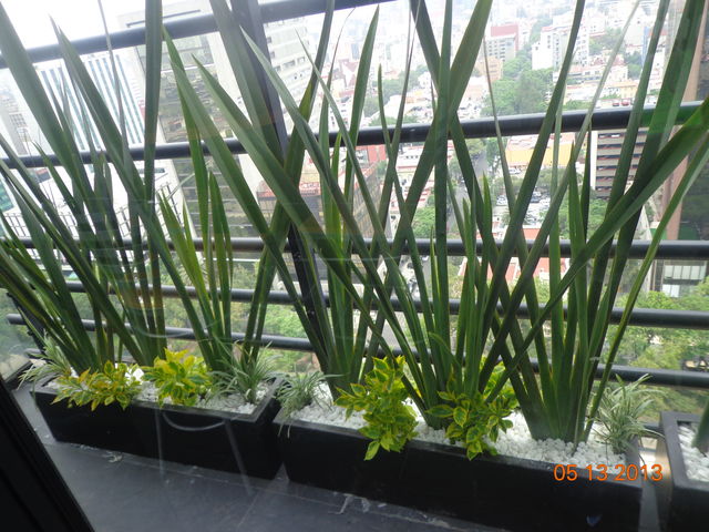 jardinera de fibra de vidrio decorada con fornio doranta y piedra de rio